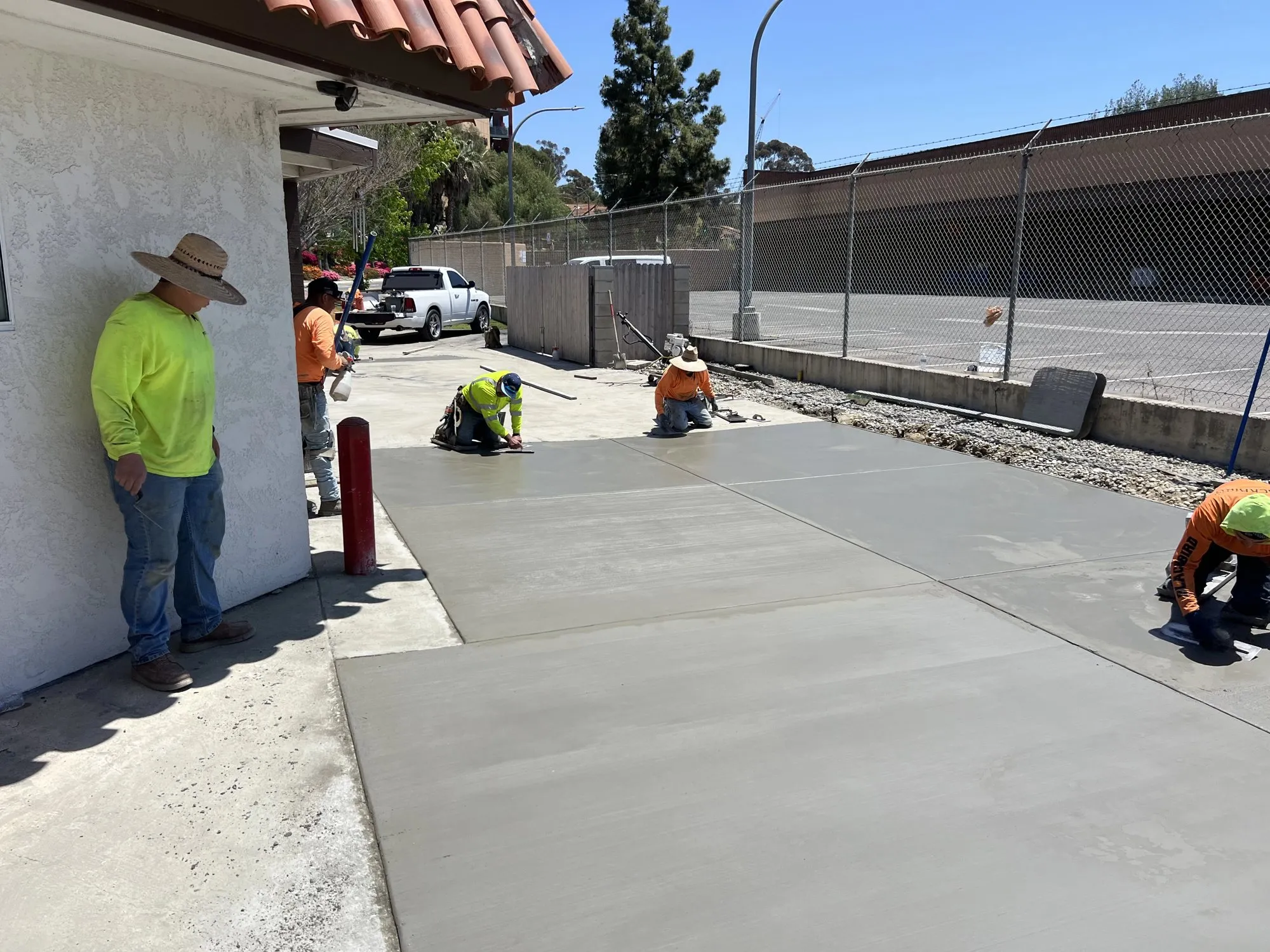 Crew finishing a freshly poured concrete slab